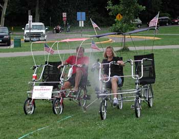 Todd Walker and Jean Golden riding Quadribents across the grass when sprinkler goes on